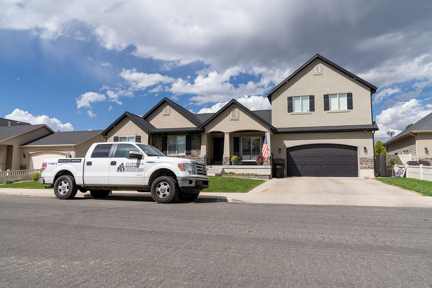 A Silverback Roofing truck in front of a large, beautiful home in a nice neighborhood.